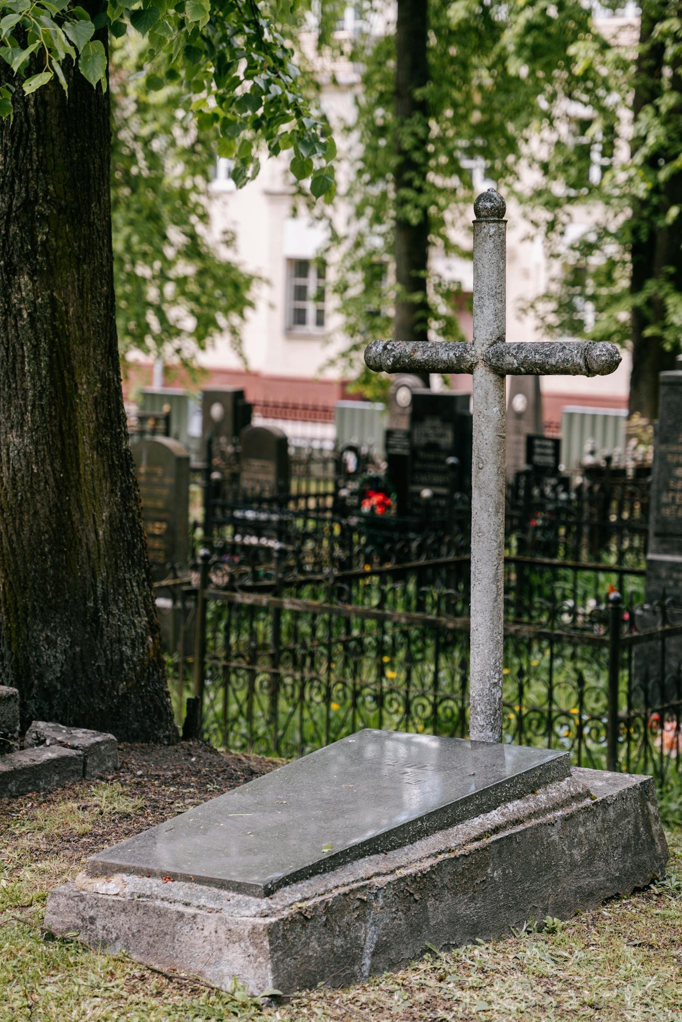 A serene cemetery scene with historic tombstones amidst lush green trees, exuding a peaceful ambiance.