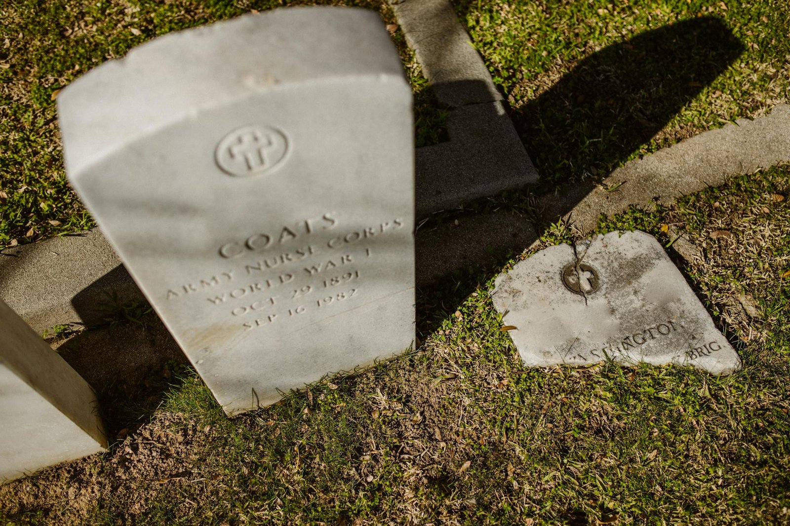 Vintage white gravestones in a sunlit cemetery, evoking a sense of remembrance and honor.