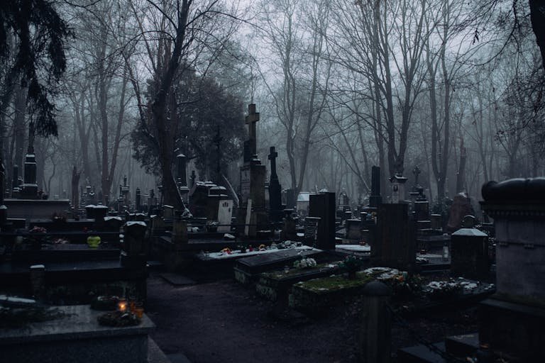 Eerie winter cemetery scene with fog and numerous gravestones and crosses. What happens to graves after 100 years.