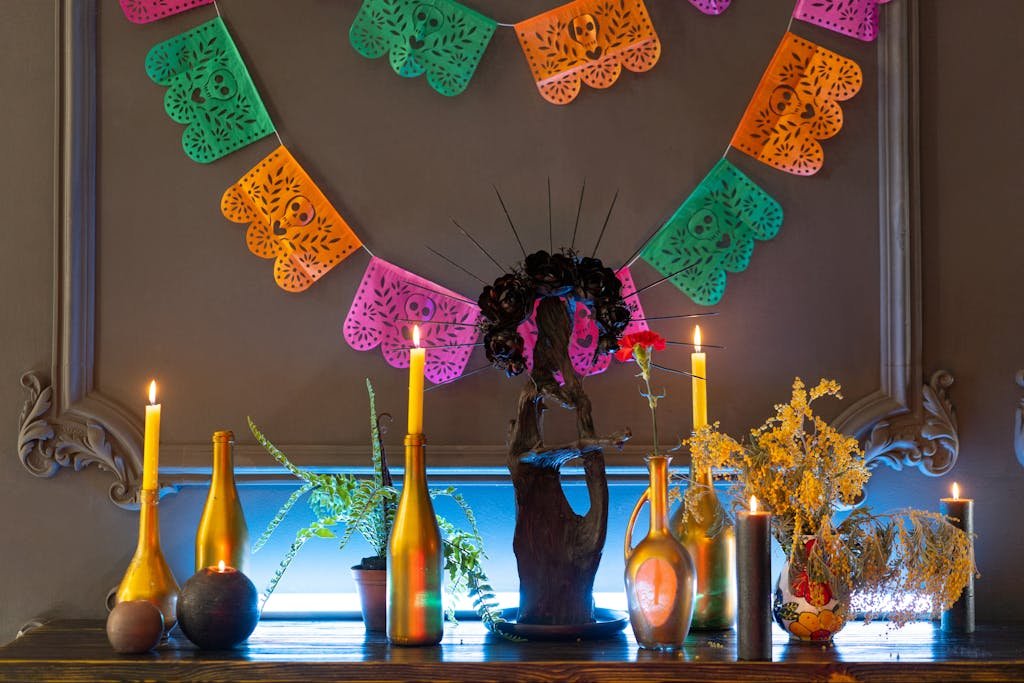 Vibrant Day of the Dead setup with candles, plants, and traditional decorations.